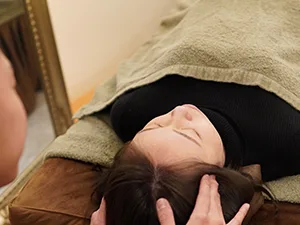 頭のマッサージを受ける女性