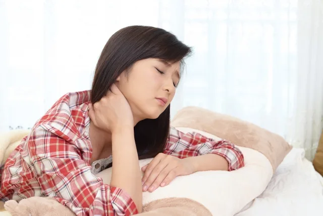 首を押さえる女性