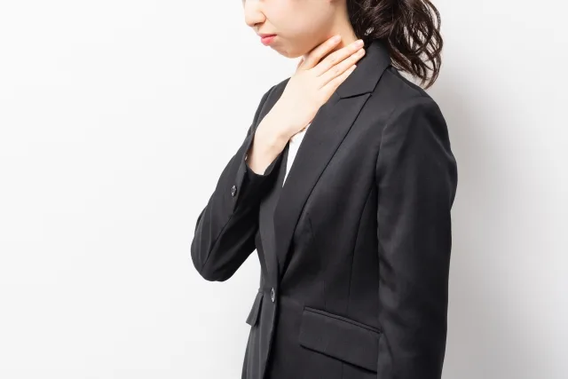 喉を押さえる女性