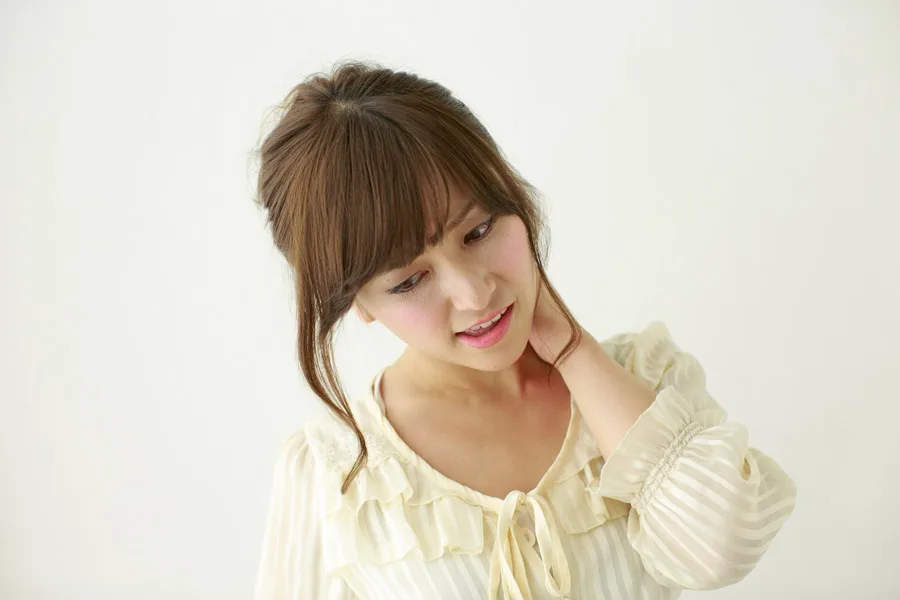むちうちによる首の痛みを我慢している女性