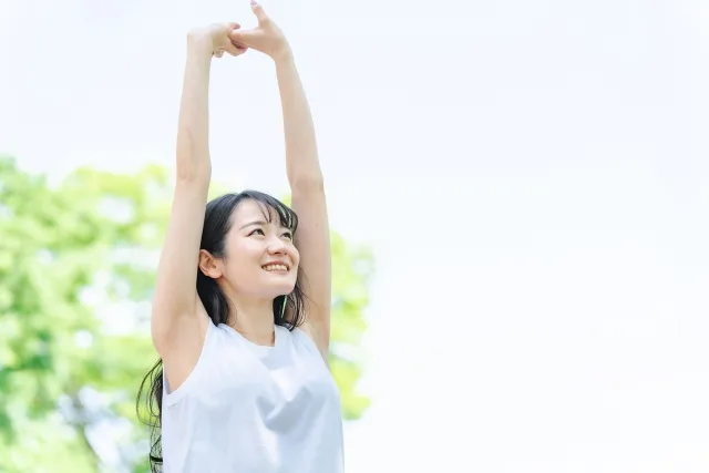 腕を上げのびをしている人