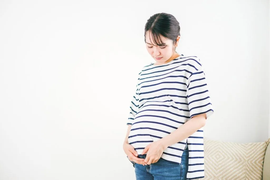 大きなお腹を抱える女性