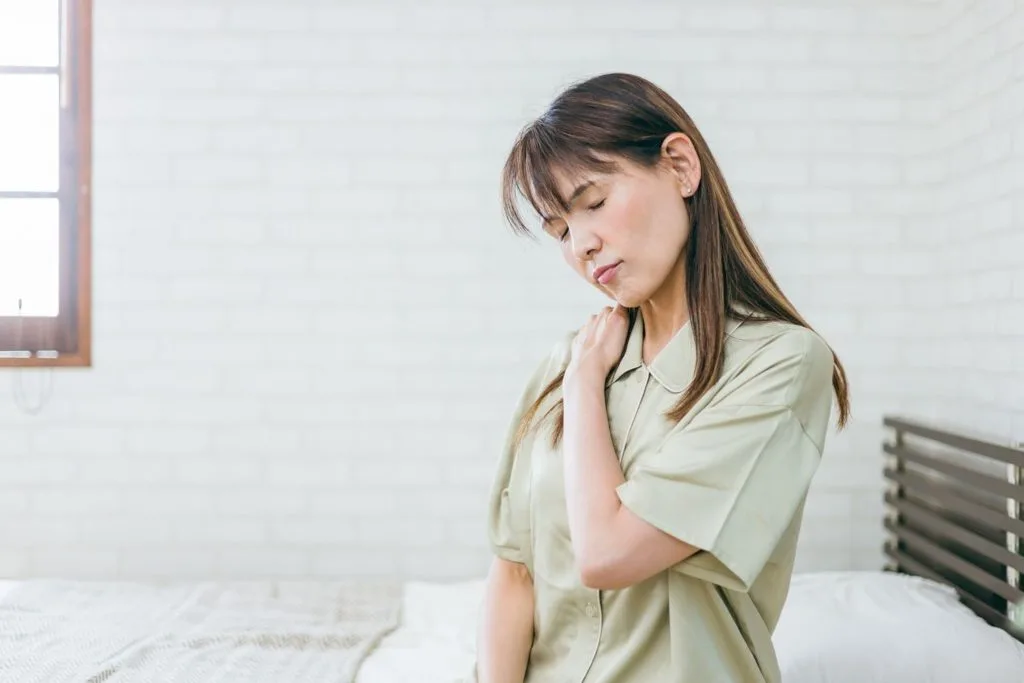 肩を押さえる女性