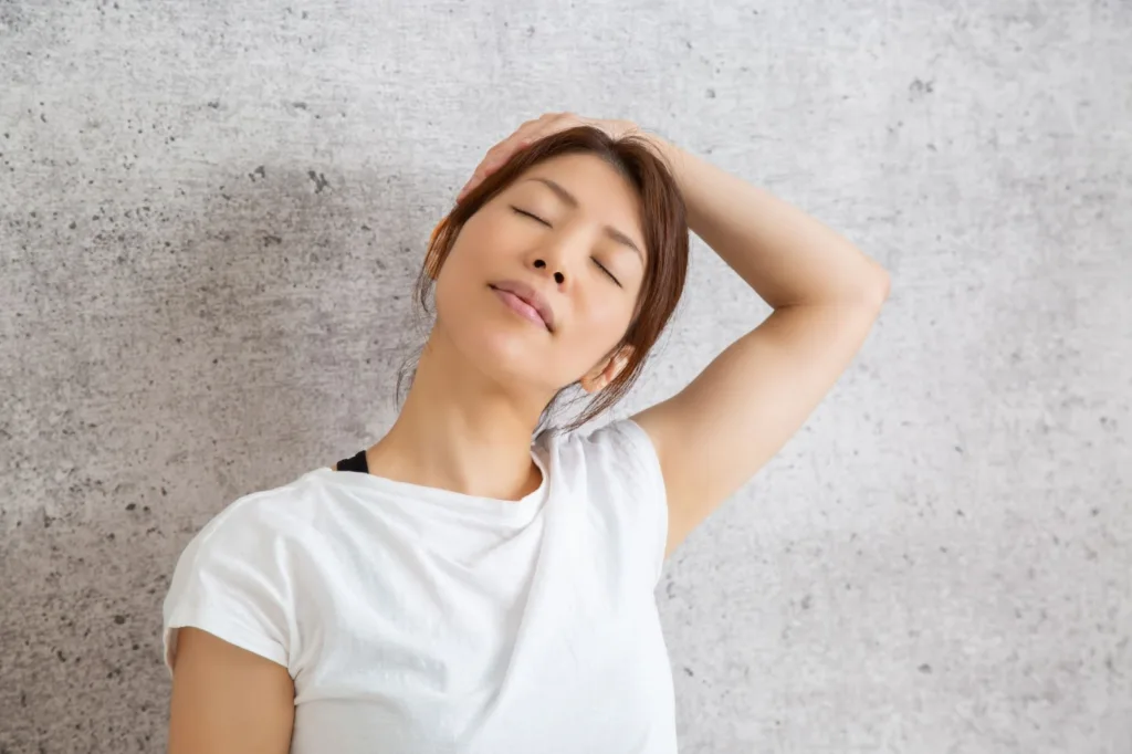 左手を使って首をストレッチする女性