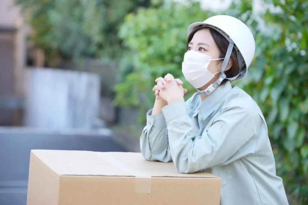 段ボールに肘をついている女性