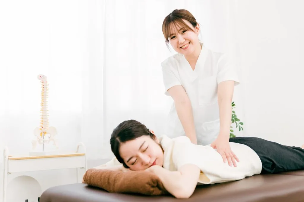 腰を治療する女性と患者