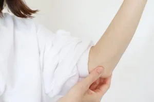 肘を抑える女性