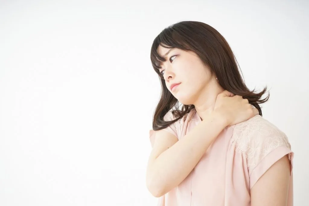 左肩を押さえる女性
