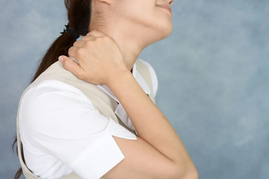 右手で首を押さえる女性