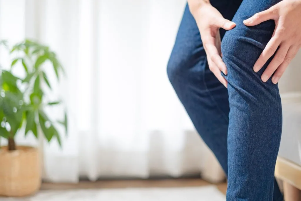 立ちながら両手で膝を押さえる様子