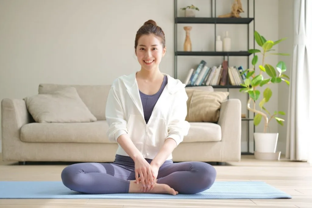 あぐらをかいて股関節をストレッチしている女性