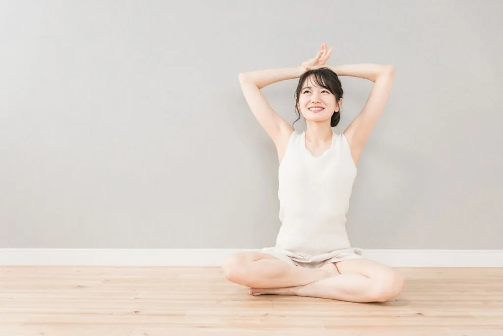 あぐらをかいてストレッチをする女性