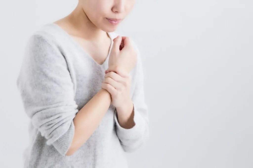 右手首を押さえる女性