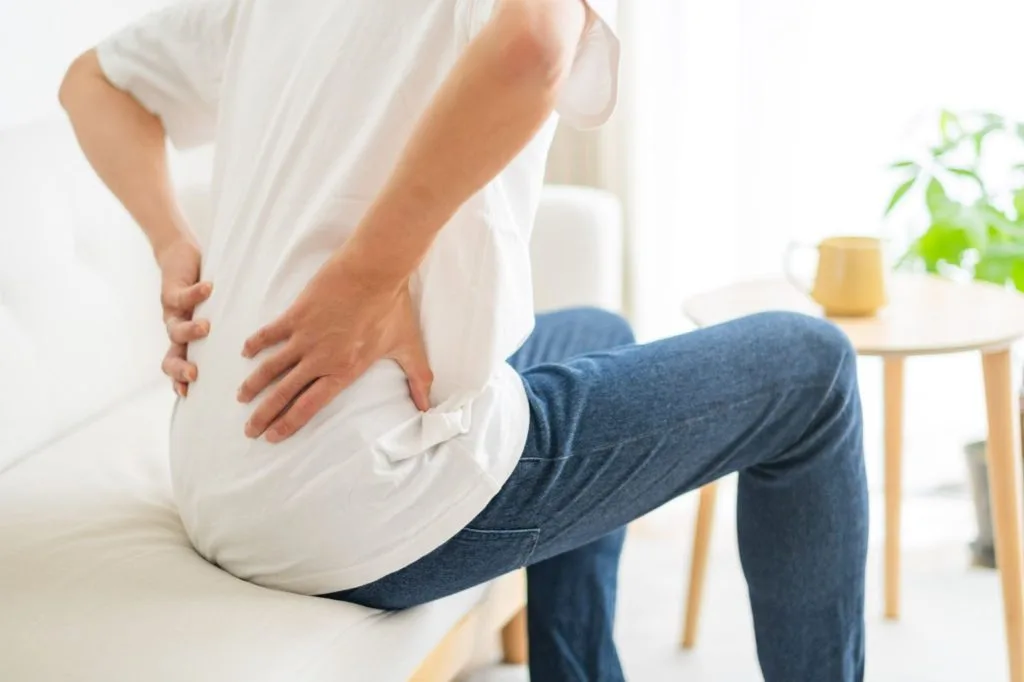 座りながら両手で腰に手を当てる様子