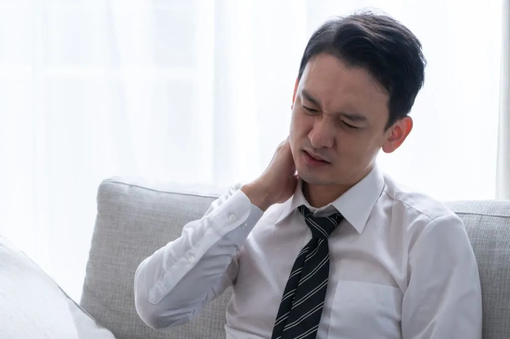 首を押さえる男性