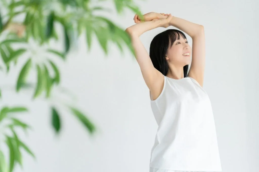 手を上げて伸びをする女性