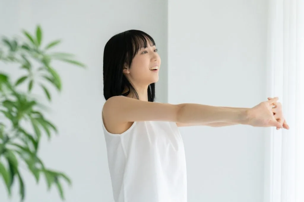 手を前で組んで伸ばす女性