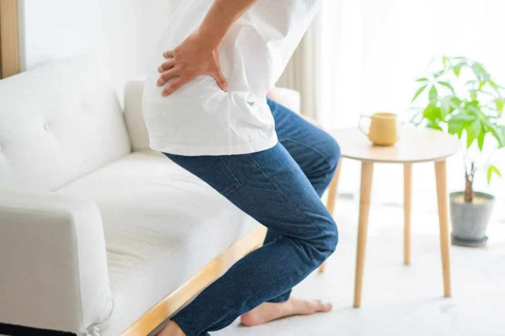 急な痛みで腰をおさえる男性