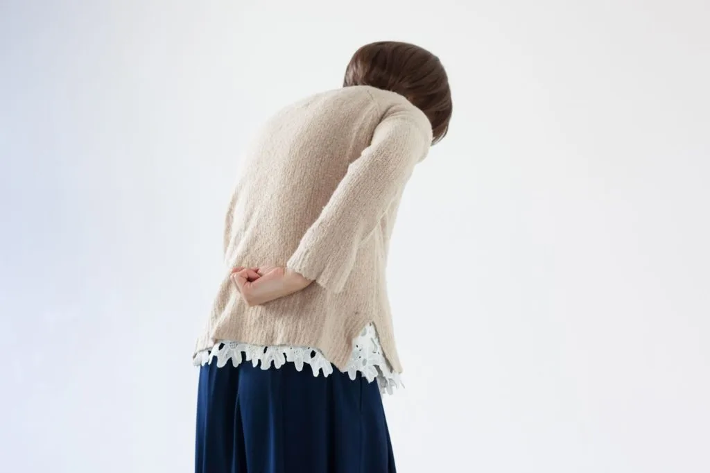 腰の辺りを気にする女性