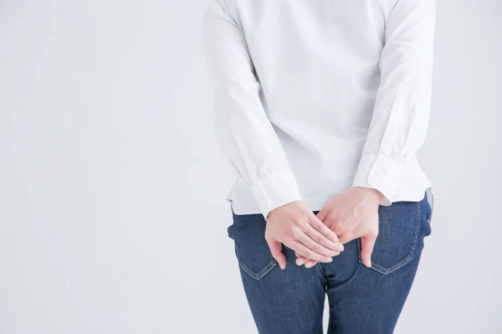 おしりの辺りを気にする女性