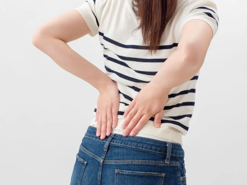 腰をおさえる女性