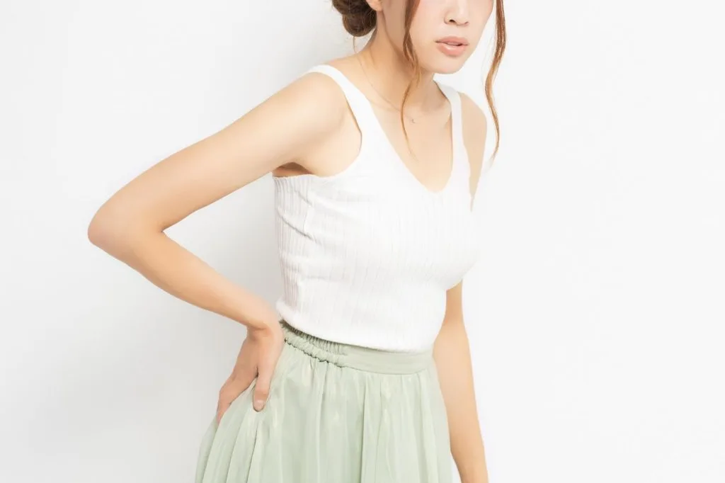 腰に手を当てている女性