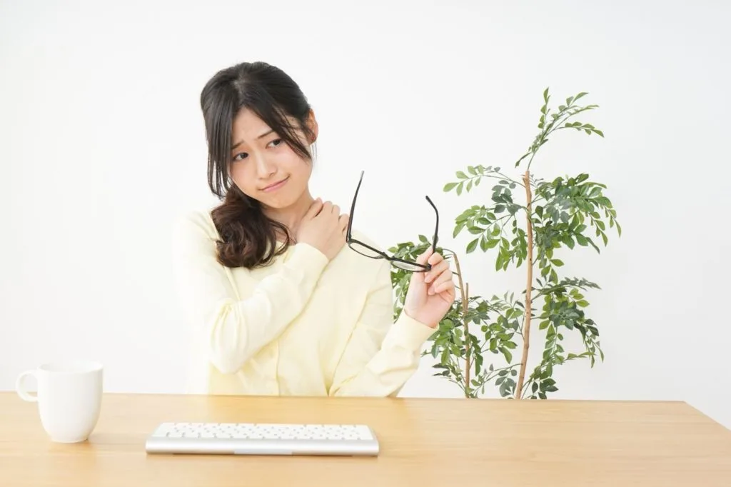 肩の辺りを気にする女性