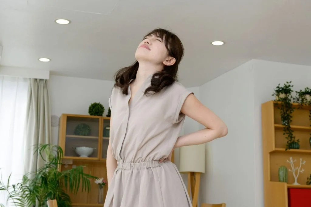 腰の痛みを気にする女性