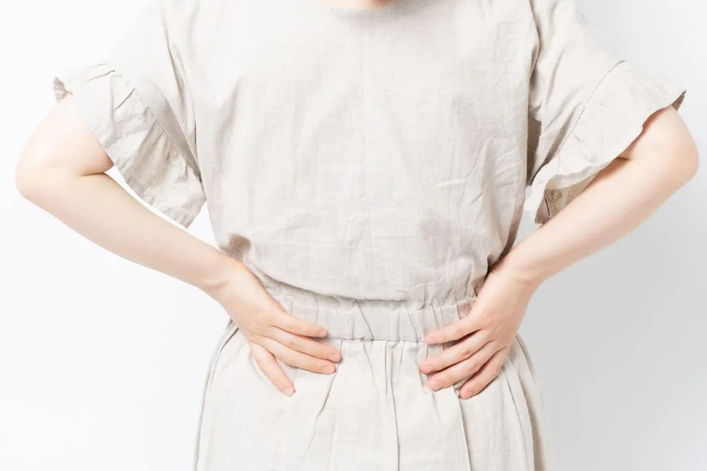 腰に手を当てる女性