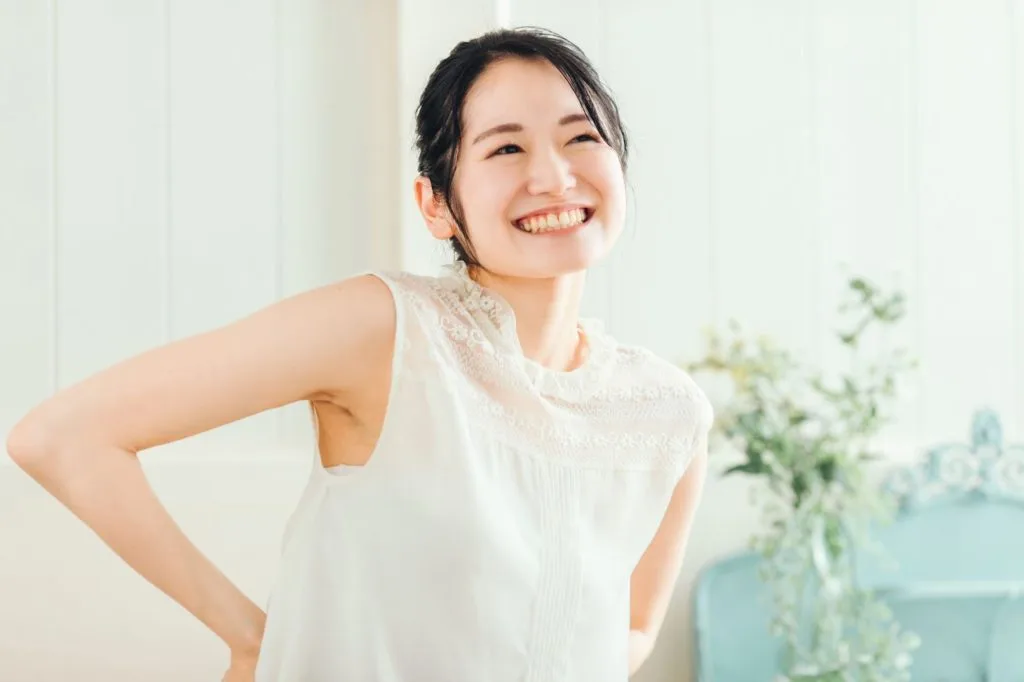 腰に手を当てて喜ぶ女性