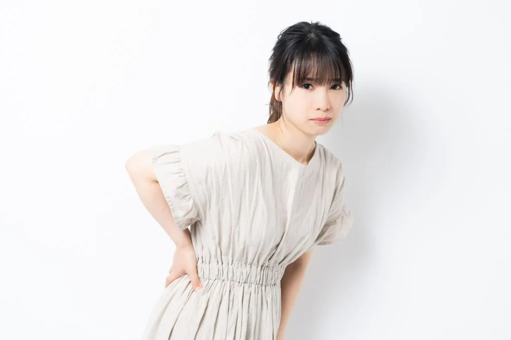 腰の辺りを気にする女性