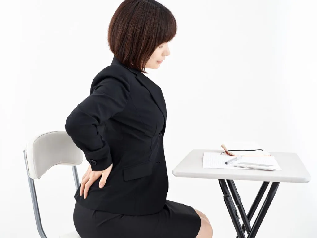 腰の辺りを気にする女性