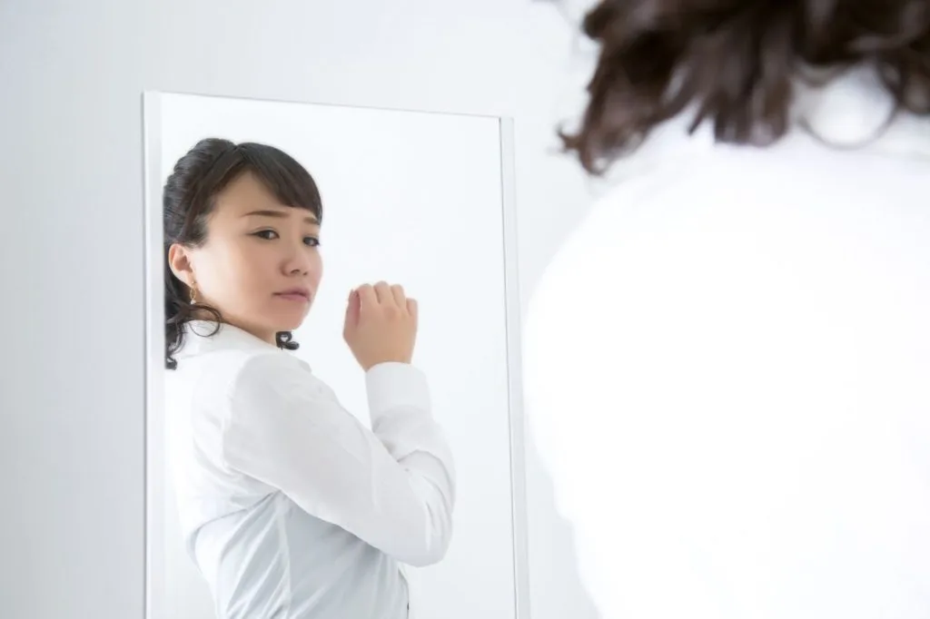 鏡で自分を見る女性