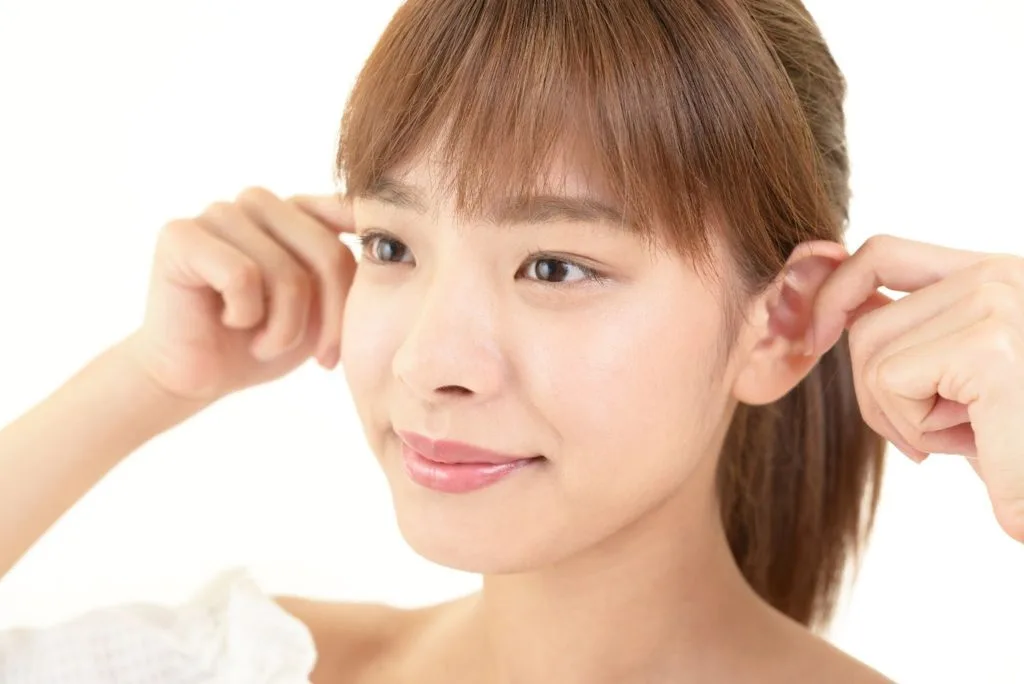 耳のツボを刺激する女性