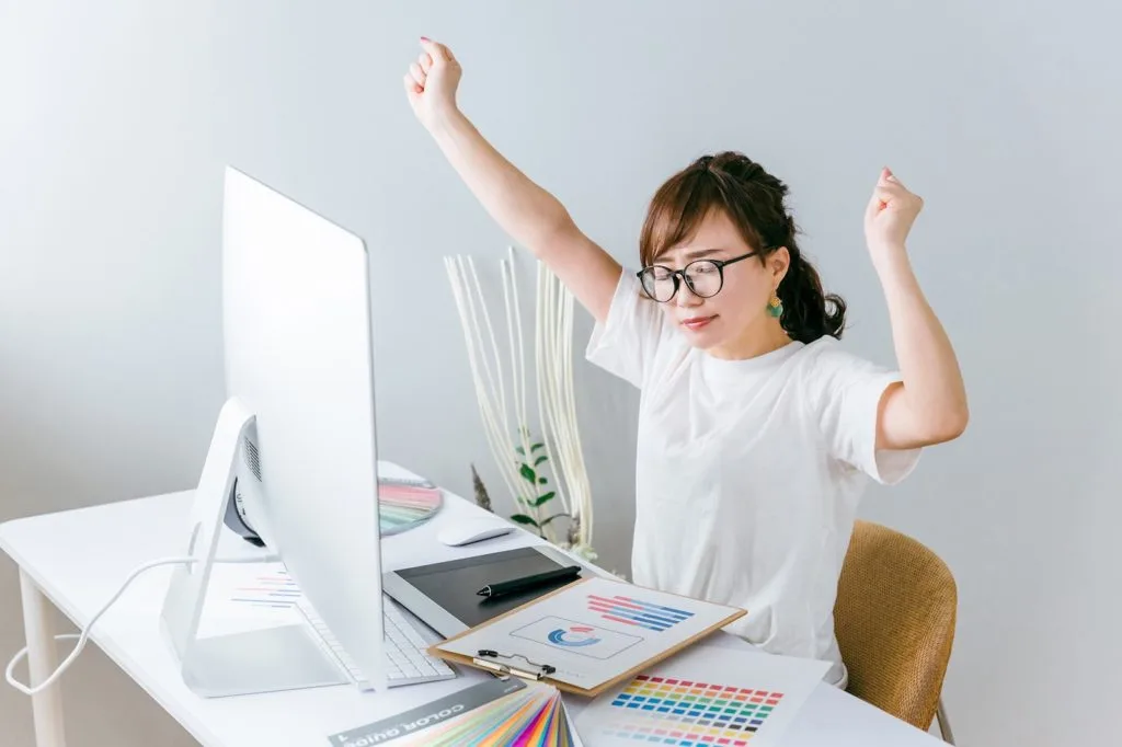 デスクワークの際にストレッチをする女性
