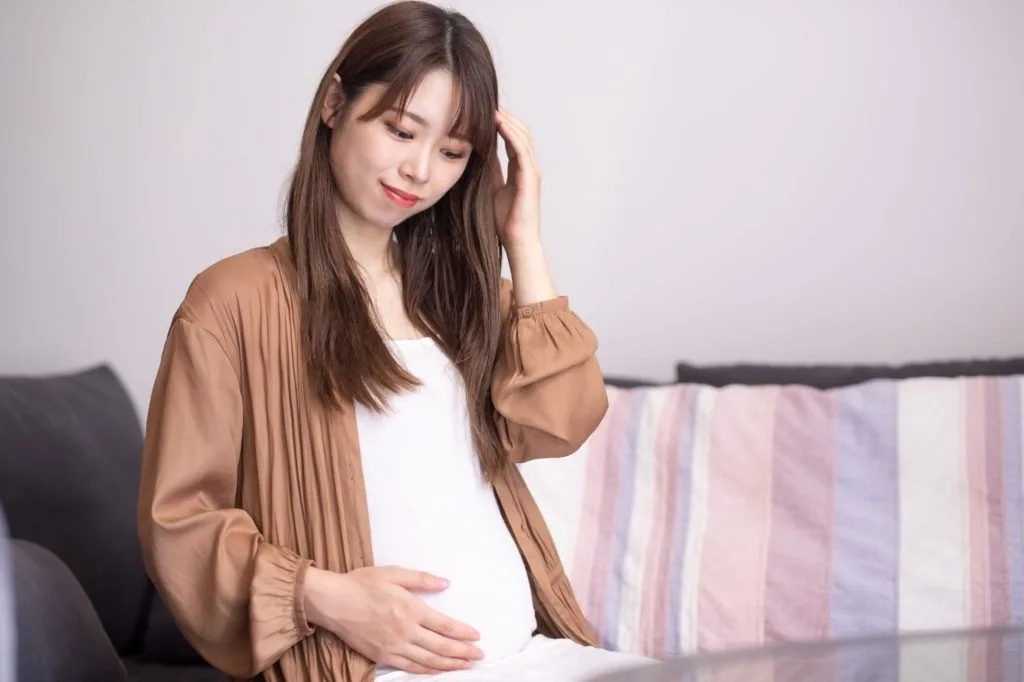 お腹に手を当てる妊娠している女性
